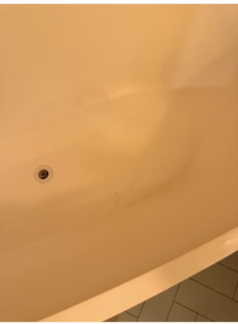 Bathtub before cleaning — grime and staining near drain