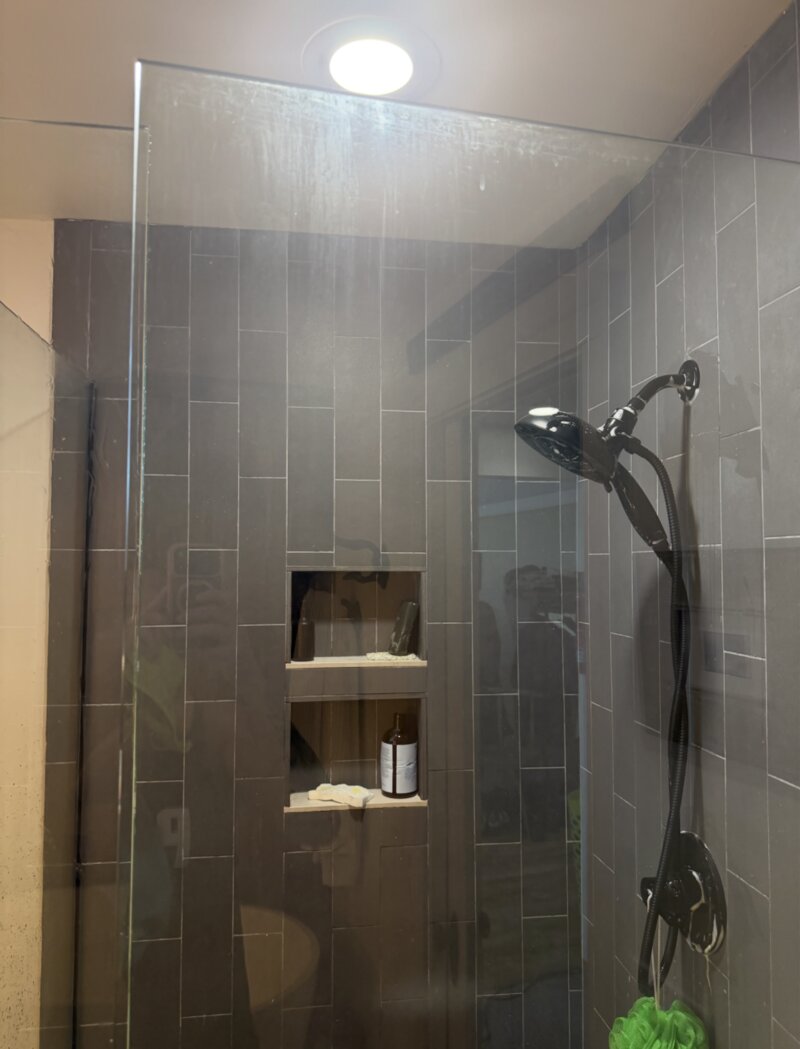 Shower glass before cleaning — foggy and water-spotted